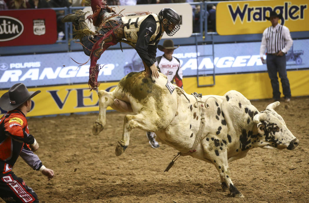 Dustin Bowen gets bucked off by bull Piano Bar Bandit while competing in the bull riding event during the second night of the National Finals Rodeo at the Thomas & Mack Center in Las Vegas on ...