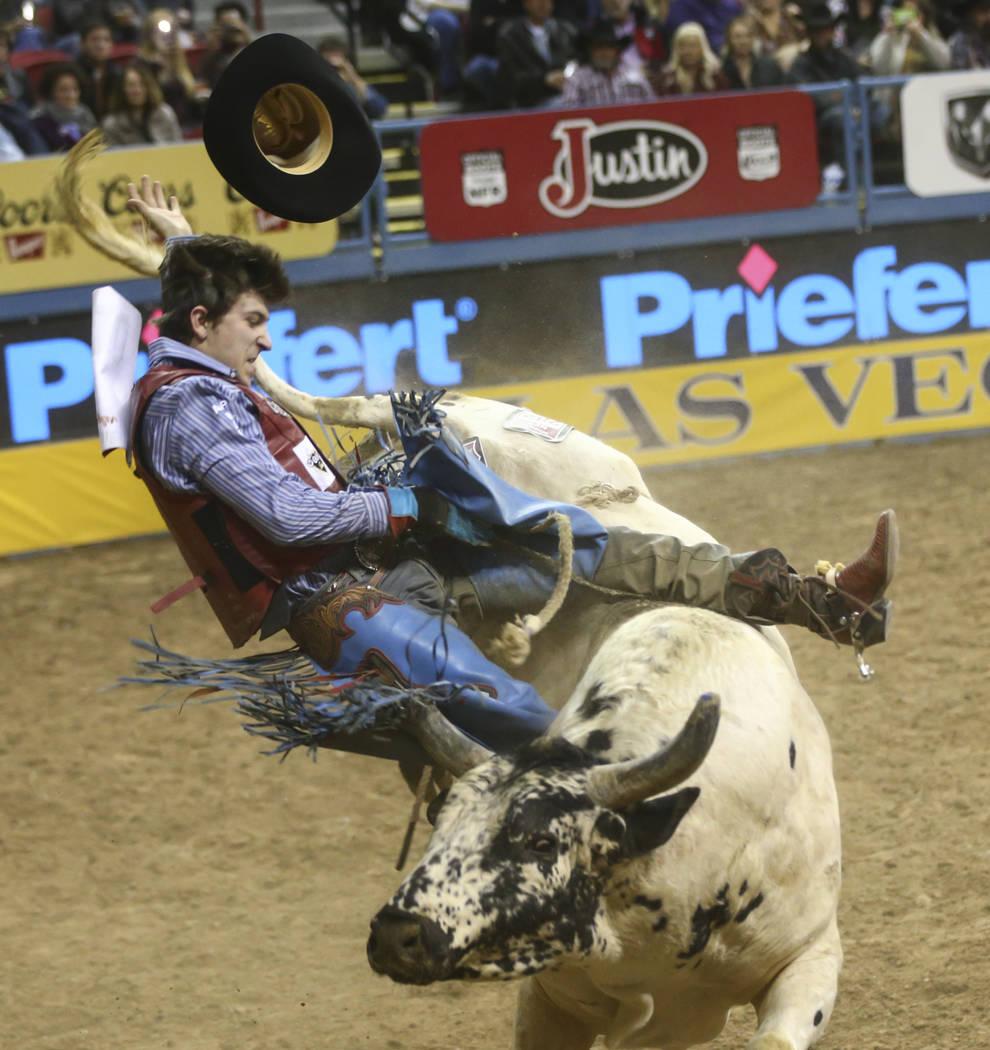 Roscoe Jarboe gets bucked off by Bull Butler while competing in the bull riding event during the second night of the National Finals Rodeo at the Thomas & Mack Center in Las Vegas on Friday, D ...