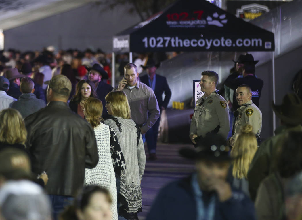 Las Vegas police keep an eye on the crowd as attendees make their way in for the second night of the National Finals Rodeo at the Thomas & Mack Center in Las Vegas on Friday, Dec. 8, 2017. Cha ...